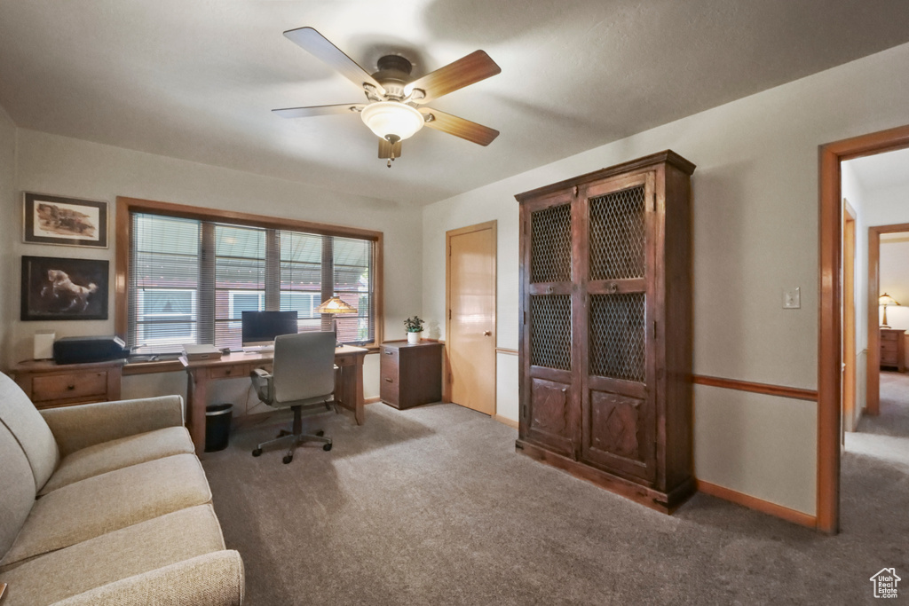 Carpeted office featuring ceiling fan and baseboards