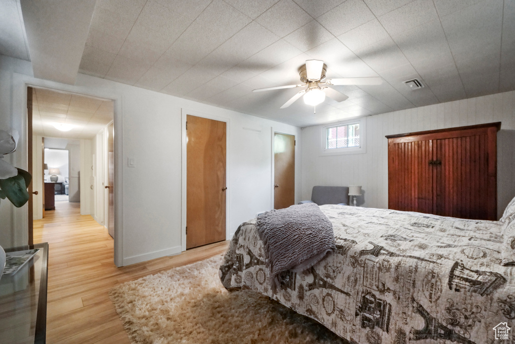 Bedroom featuring light wood-style floors, ceiling fan, and baseboards