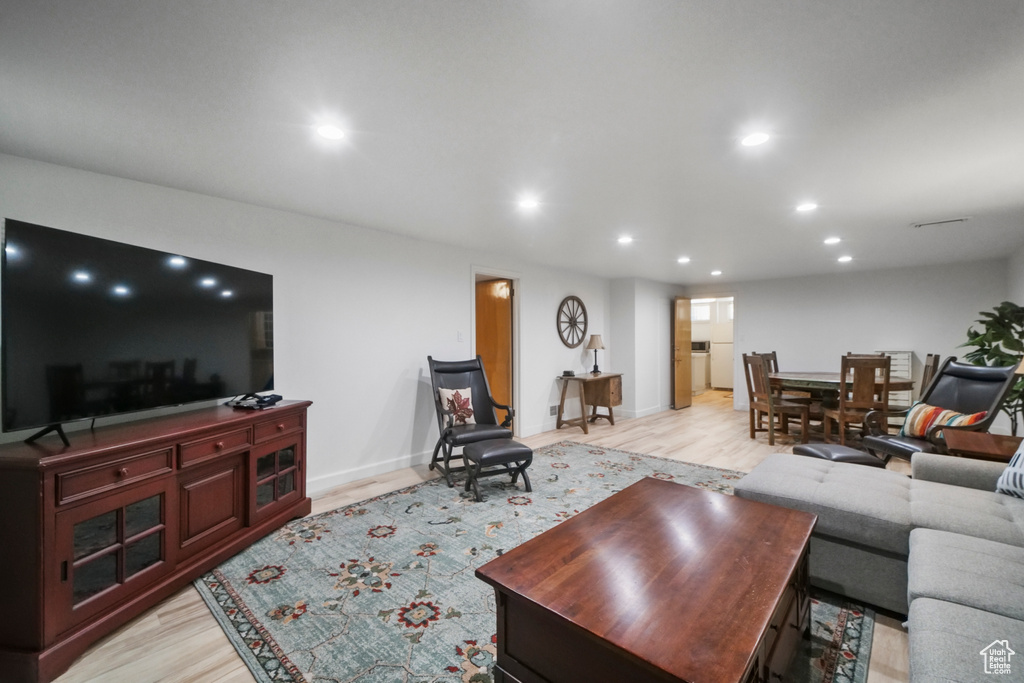 Living area with recessed lighting, light wood finished floors, and baseboards