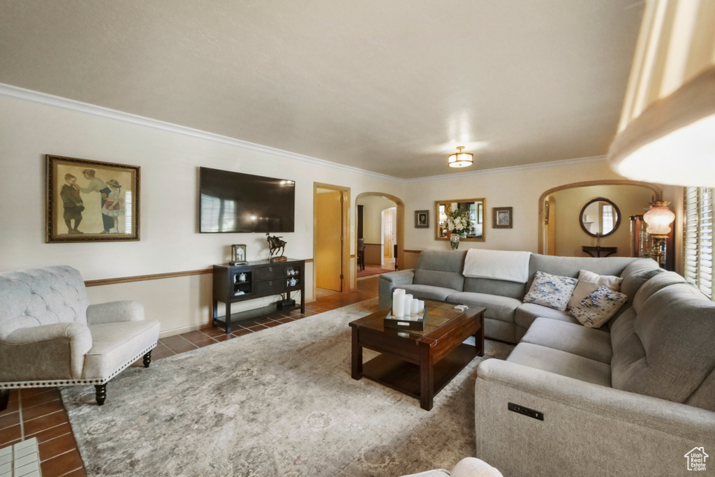 Tiled living area with arched walkways and crown molding