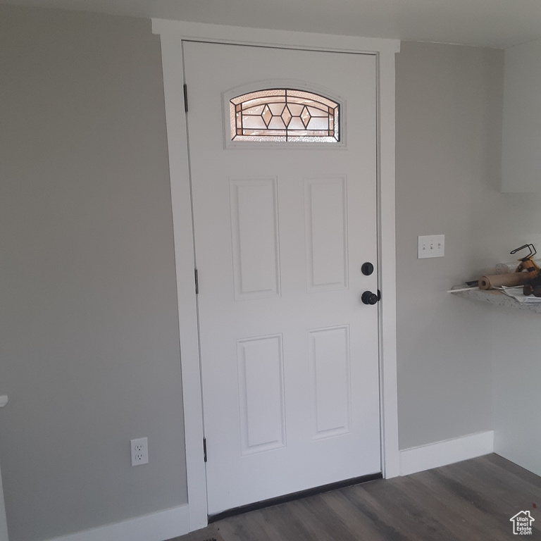 Doorway to outside featuring dark wood finished floors and baseboards