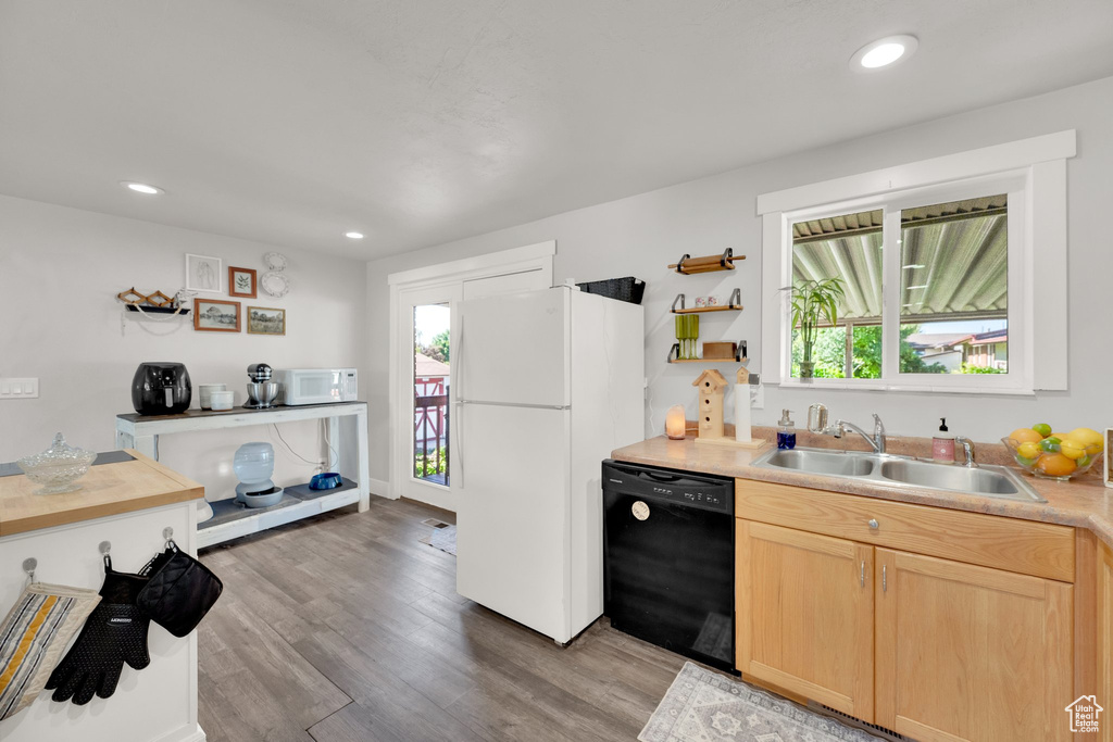 Kitchen with white appliances, a sink, light brown cabinetry, light wood finished floors, and light countertops