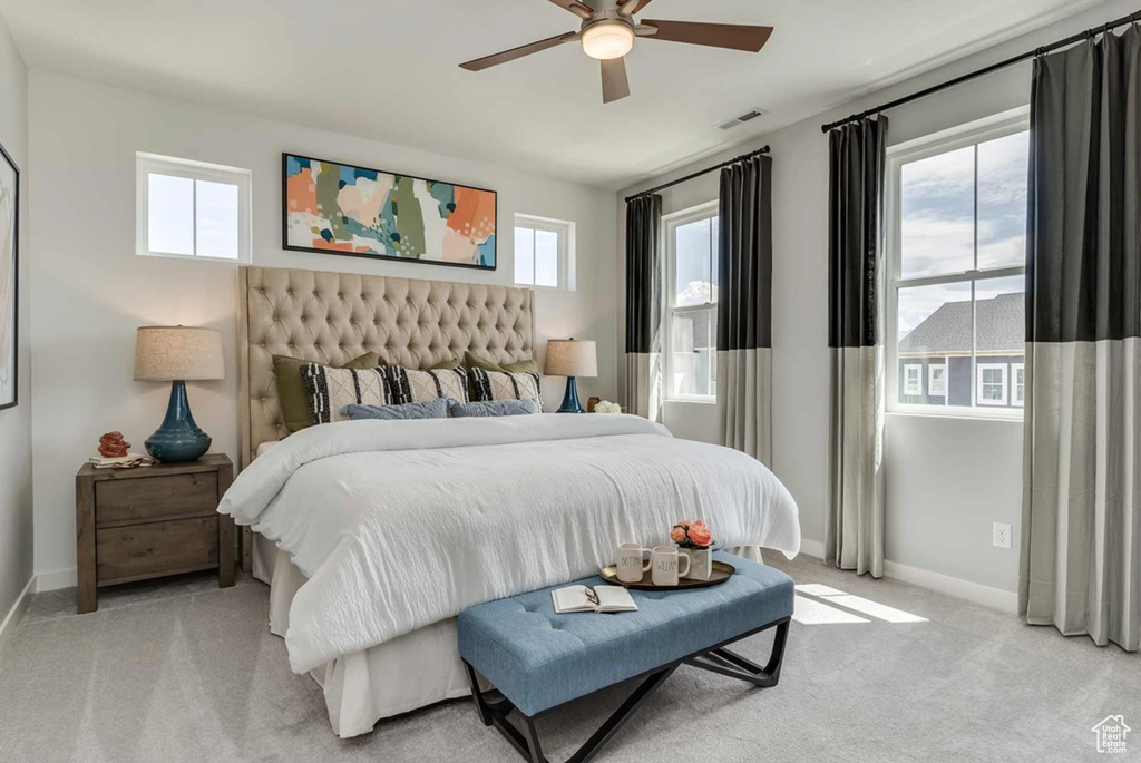 Bedroom with baseboards, light colored carpet, and ceiling fan