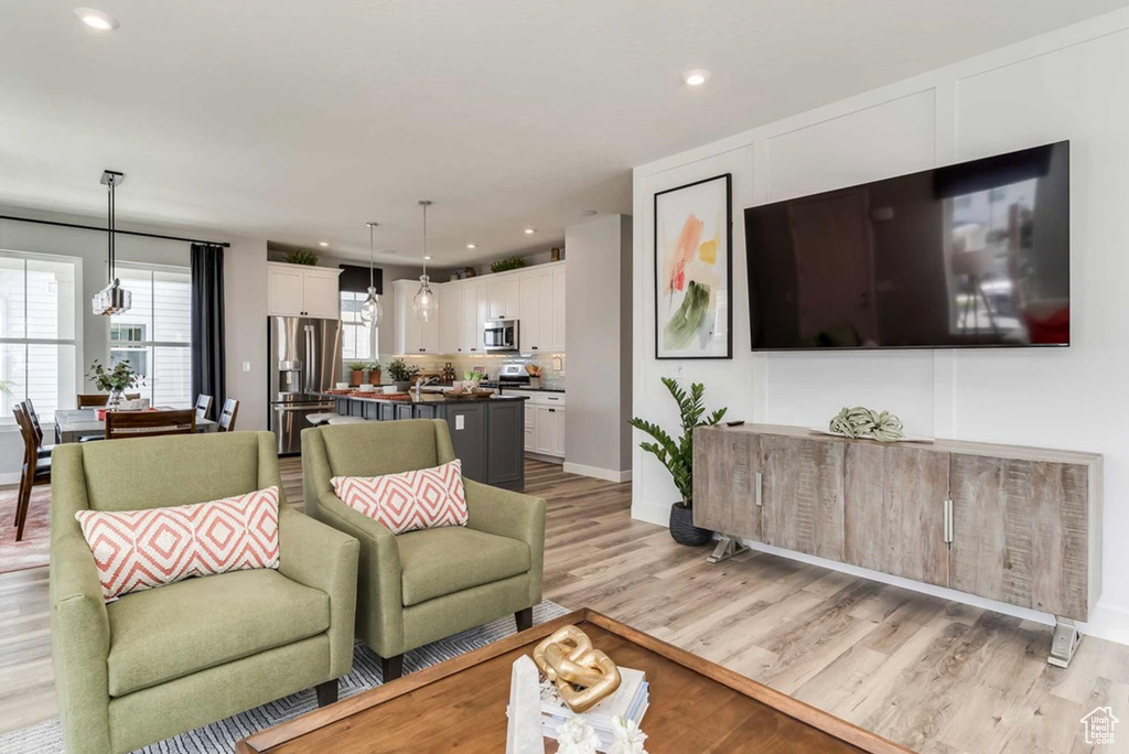 Living area with light wood finished floors, recessed lighting, and baseboards