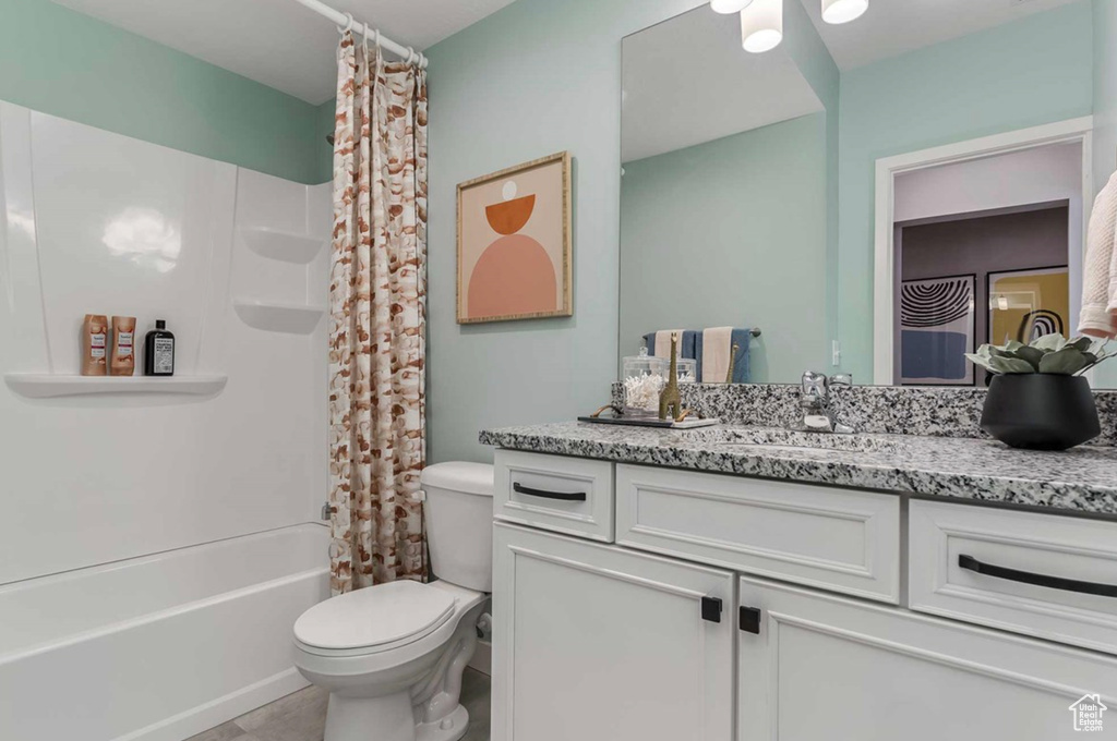 Bathroom featuring toilet, vanity, shower / bath combination with curtain, and tile patterned floors