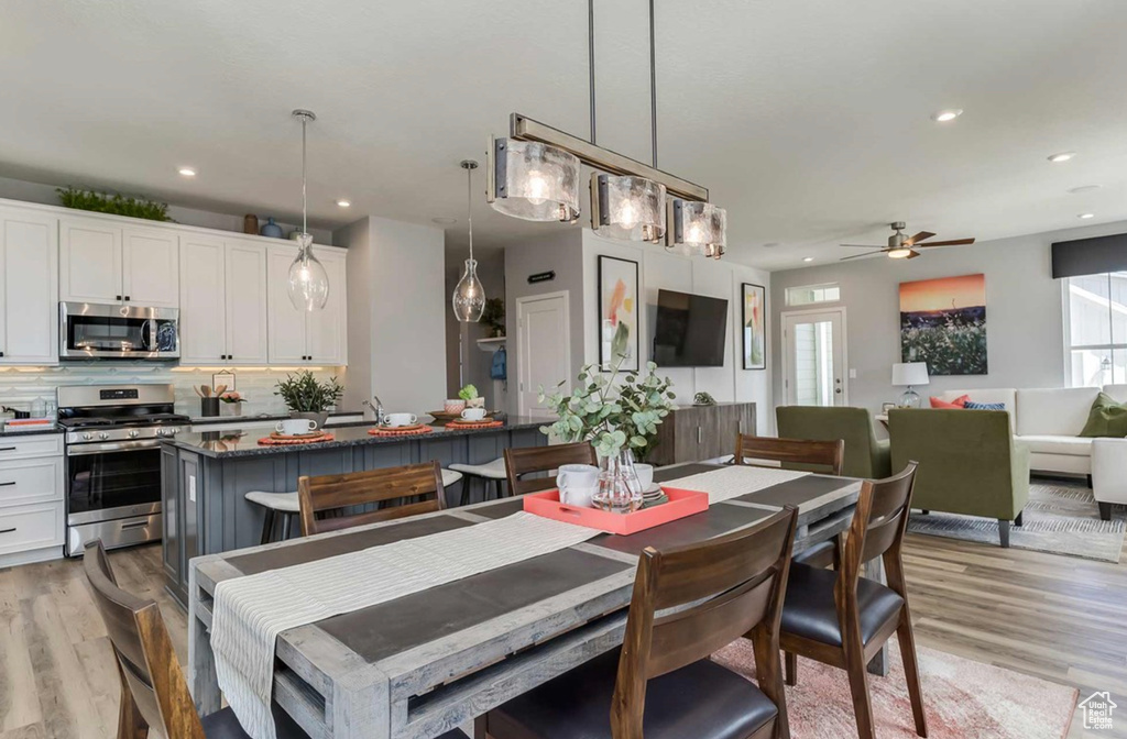 Dining room featuring light wood finished floors, a ceiling fan, and recessed lighting
