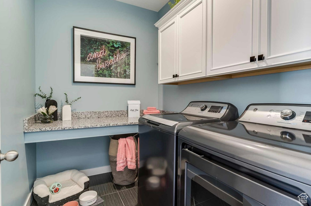 Laundry room featuring cabinet space, independent washer and dryer, and tile patterned flooring