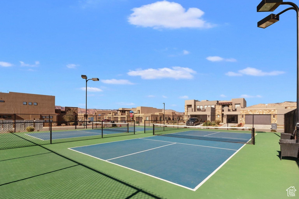 View of tennis court with a residential view and community basketball court