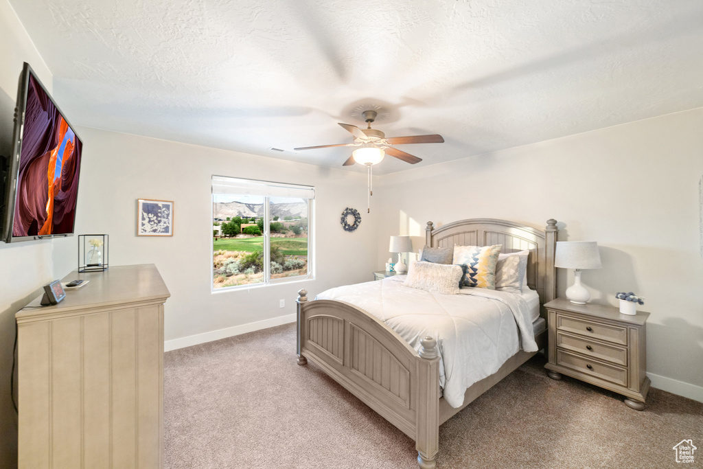 Bedroom with baseboards, light colored carpet, and a ceiling fan