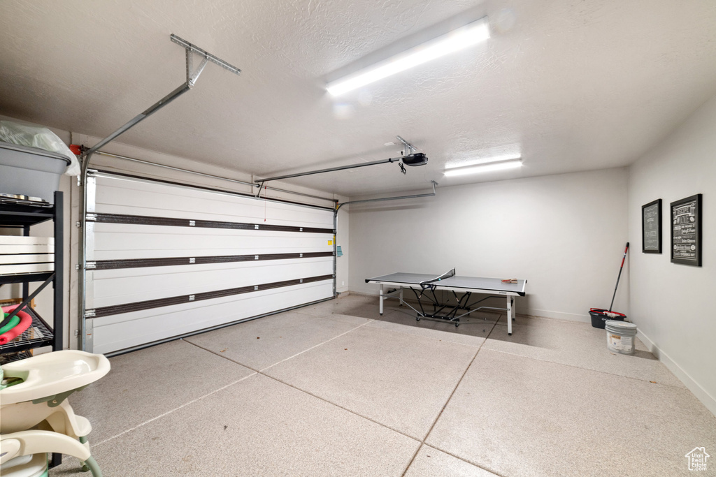Garage with baseboards and a garage door opener