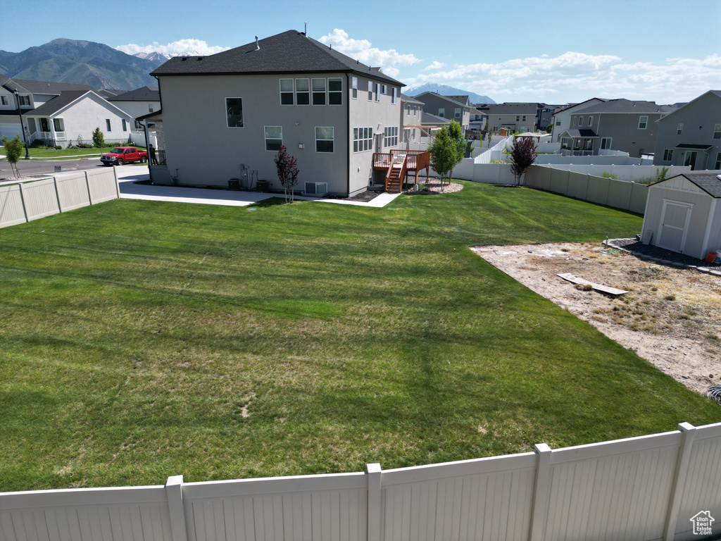 View of yard with a residential view, a patio area, and a deck with mountain view