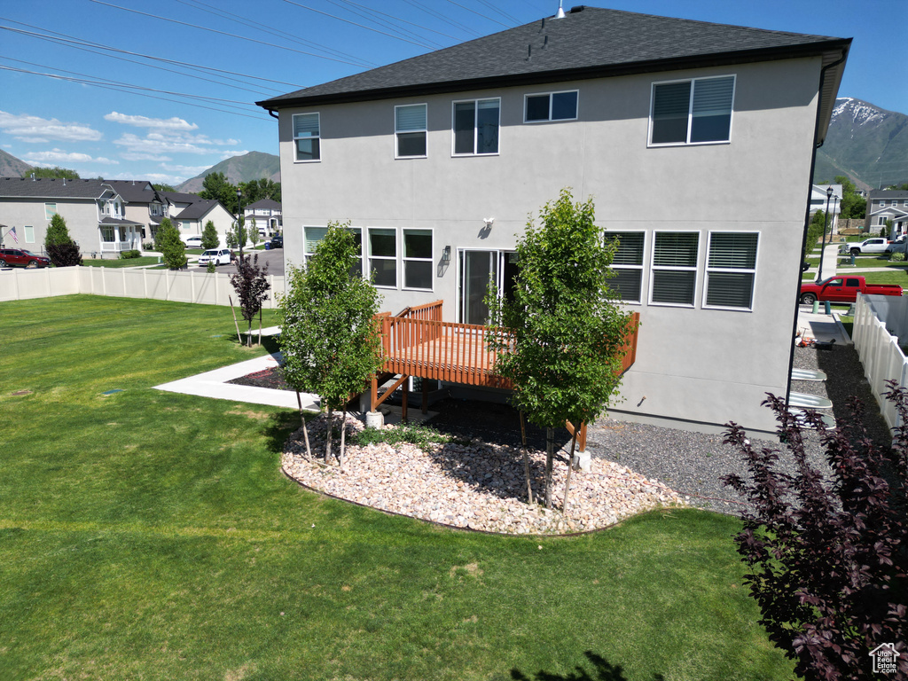 Back of property with a deck with mountain view, stucco siding, and a residential view