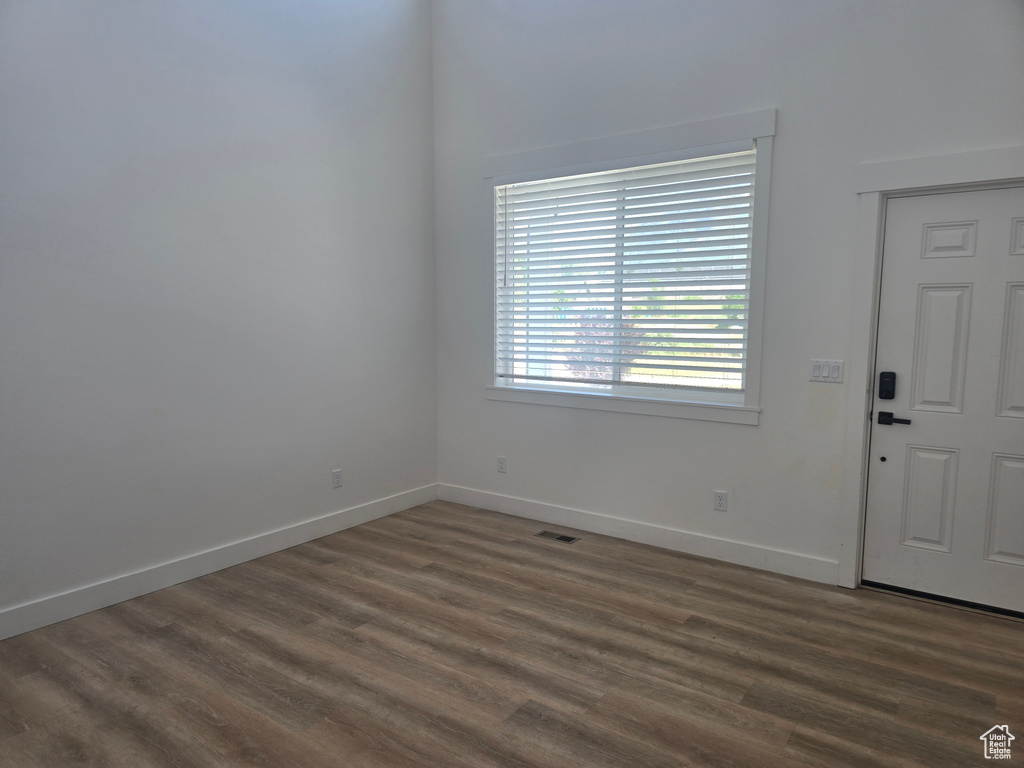 Empty room with dark wood-style flooring and baseboards