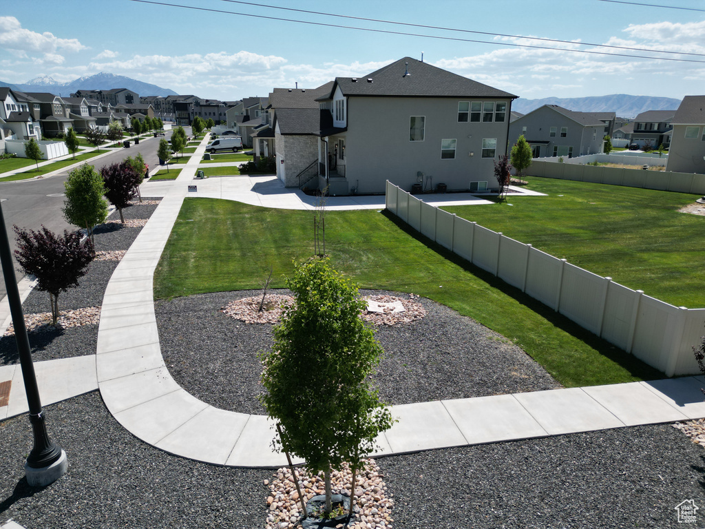 Exterior space with a residential view, a mountain view, and stucco siding