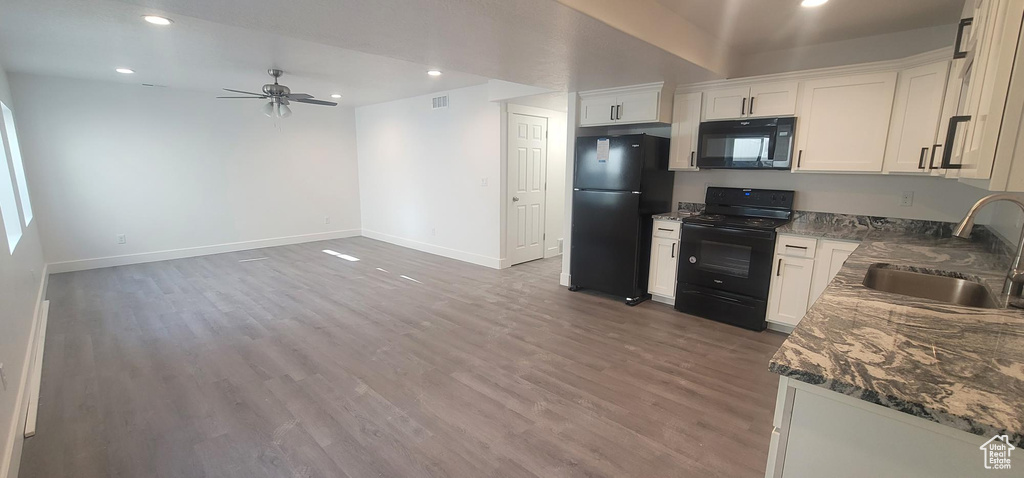 Kitchen with black appliances, a sink, ceiling fan, baseboards, and light wood-style flooring