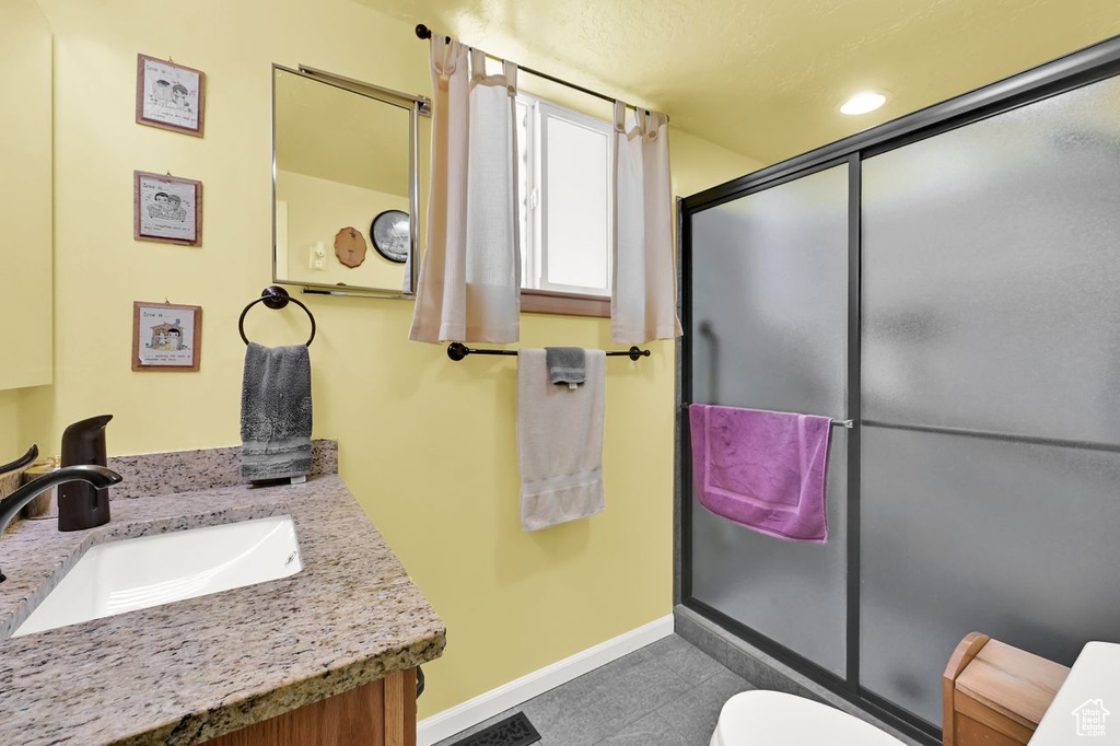Full bath featuring toilet, vanity, baseboards, a shower with shower door, and recessed lighting