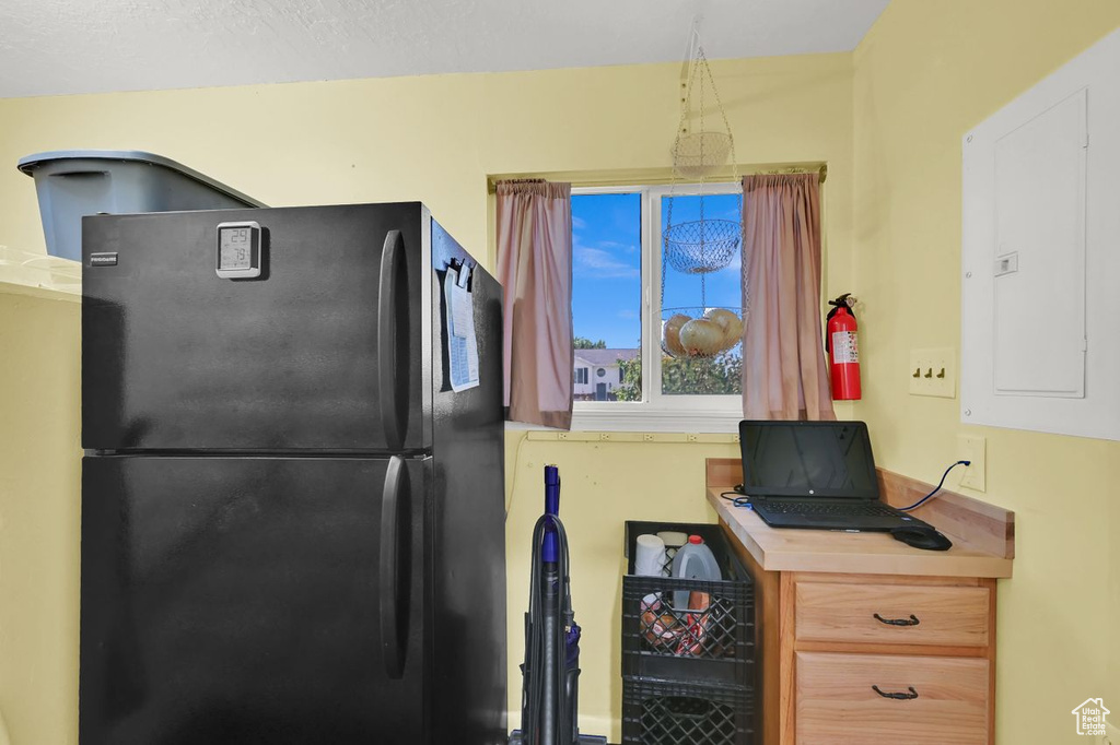 Kitchen with freestanding refrigerator, electric panel, and light countertops
