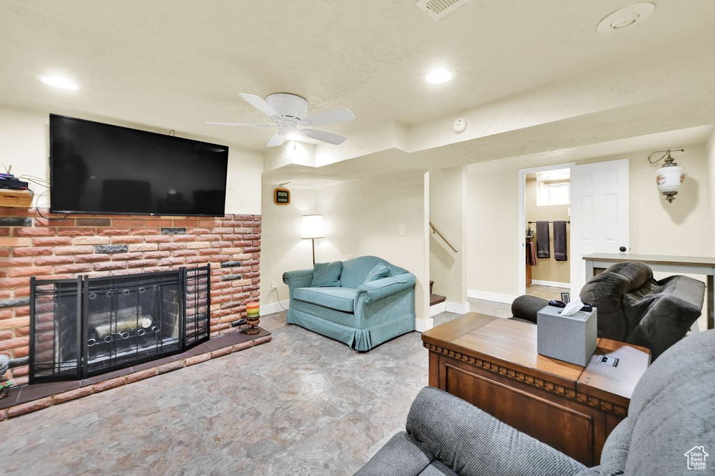 Living room with stairway, baseboards, ceiling fan, a brick fireplace, and recessed lighting