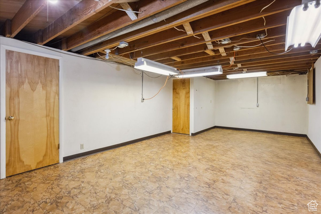 Finished basement featuring baseboards and light stone finish flooring