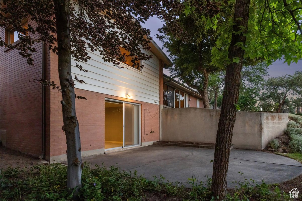 Rear view of property with a patio and brick siding