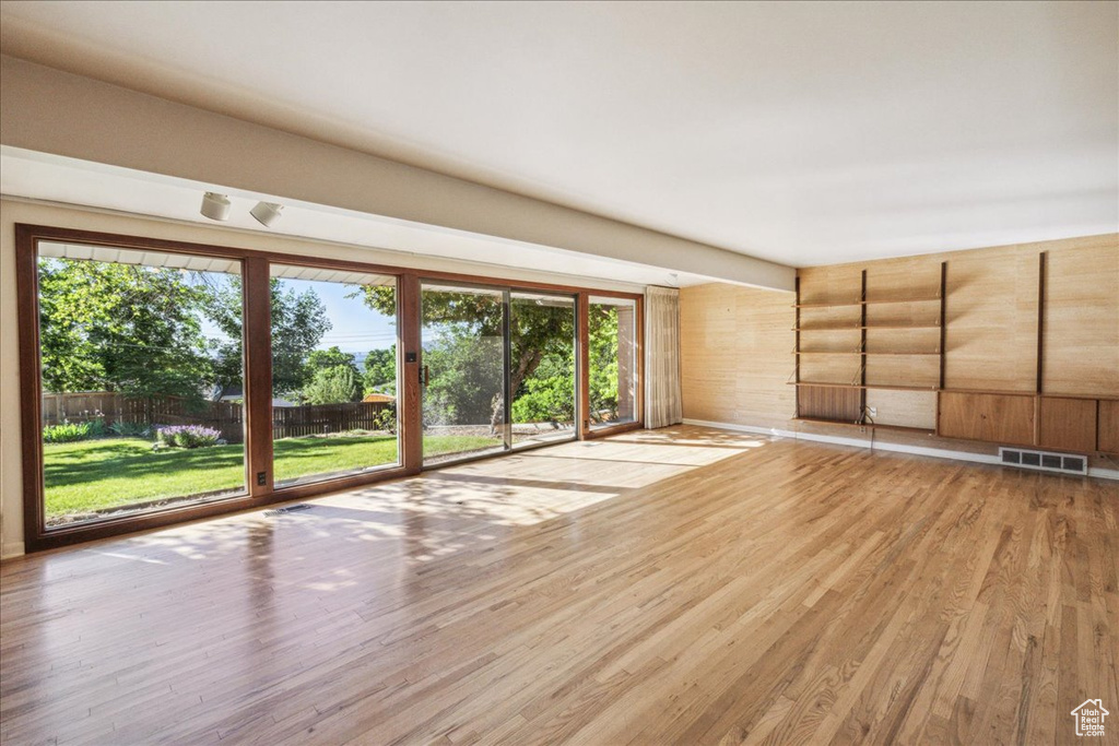 Spare room featuring light wood finished floors and wooden walls