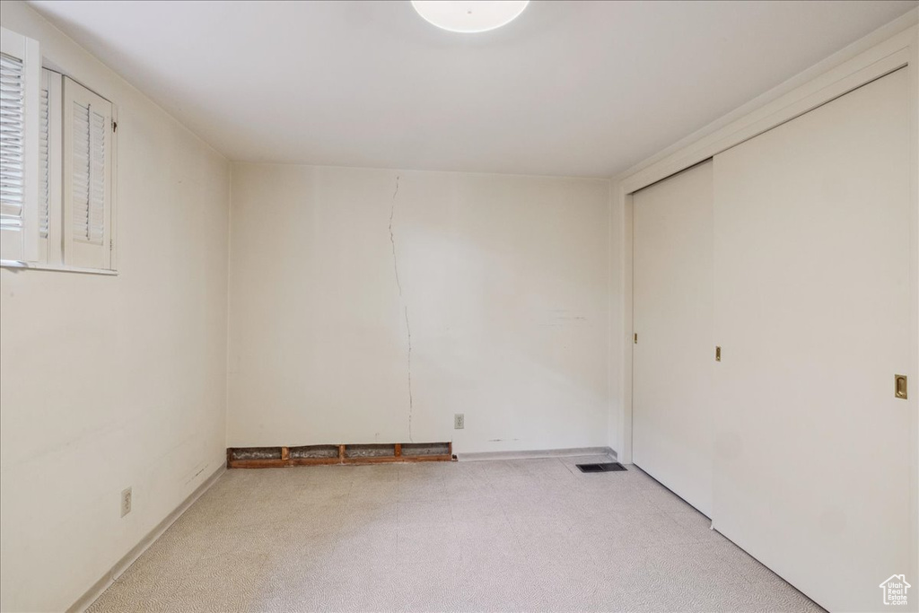 Spare room featuring light carpet and baseboards