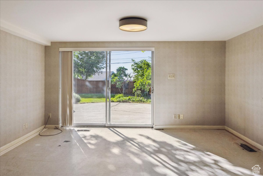 Empty room featuring concrete flooring and baseboards