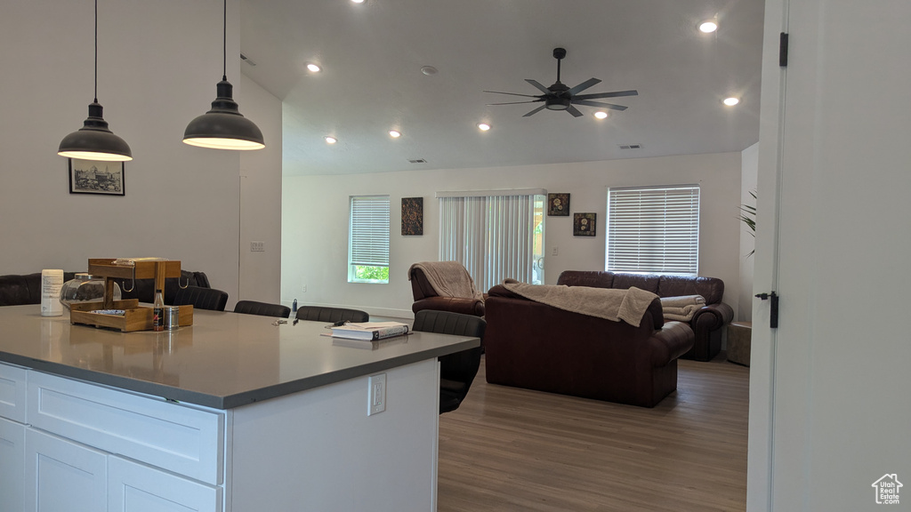 Kitchen featuring open floor plan, ceiling fan, wood finished floors, white cabinets, and recessed lighting
