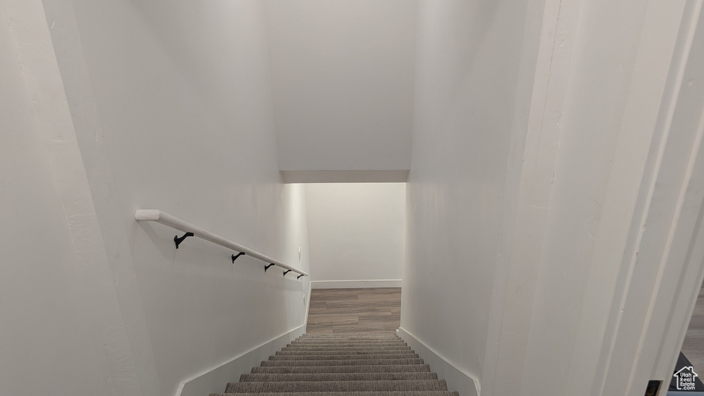 Staircase featuring baseboards and wood finished floors