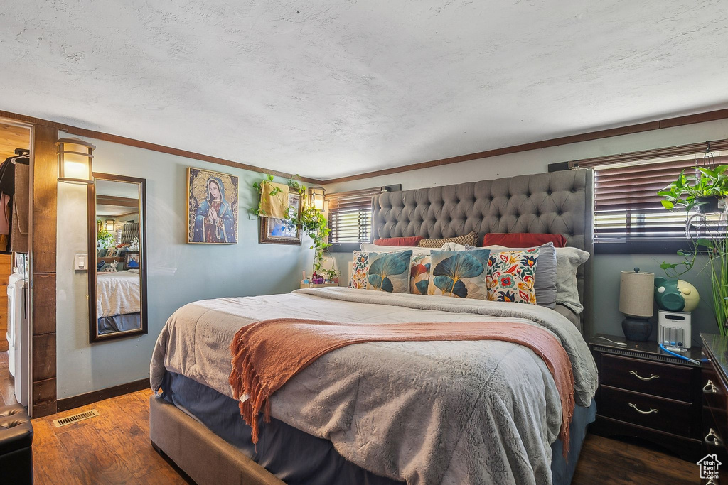 Bedroom featuring wood finished floors, ornamental molding, and baseboards