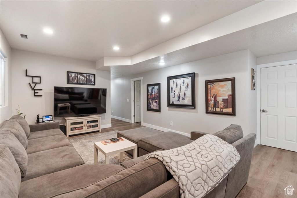 Living area with wood finished floors, recessed lighting, and baseboards