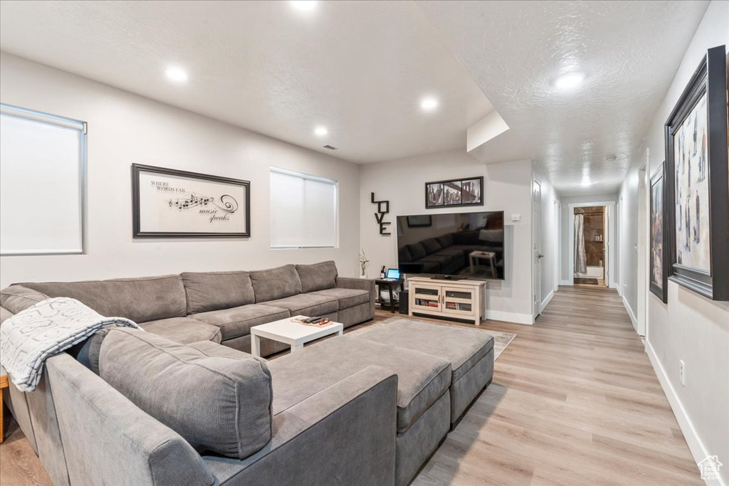 Living room featuring light wood finished floors, recessed lighting, and baseboards