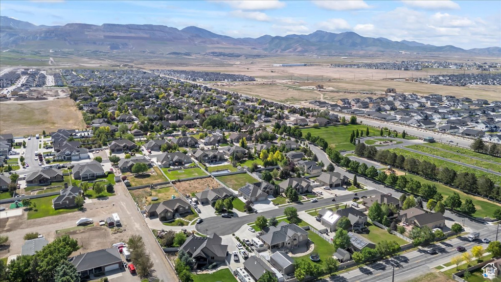 Aerial view of property and surrounding area featuring nearby suburban area and mountains