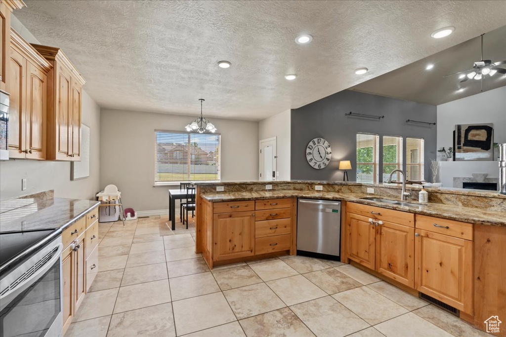 Kitchen featuring stainless steel appliances, a sink, healthy amount of natural light, light stone counters, and recessed lighting