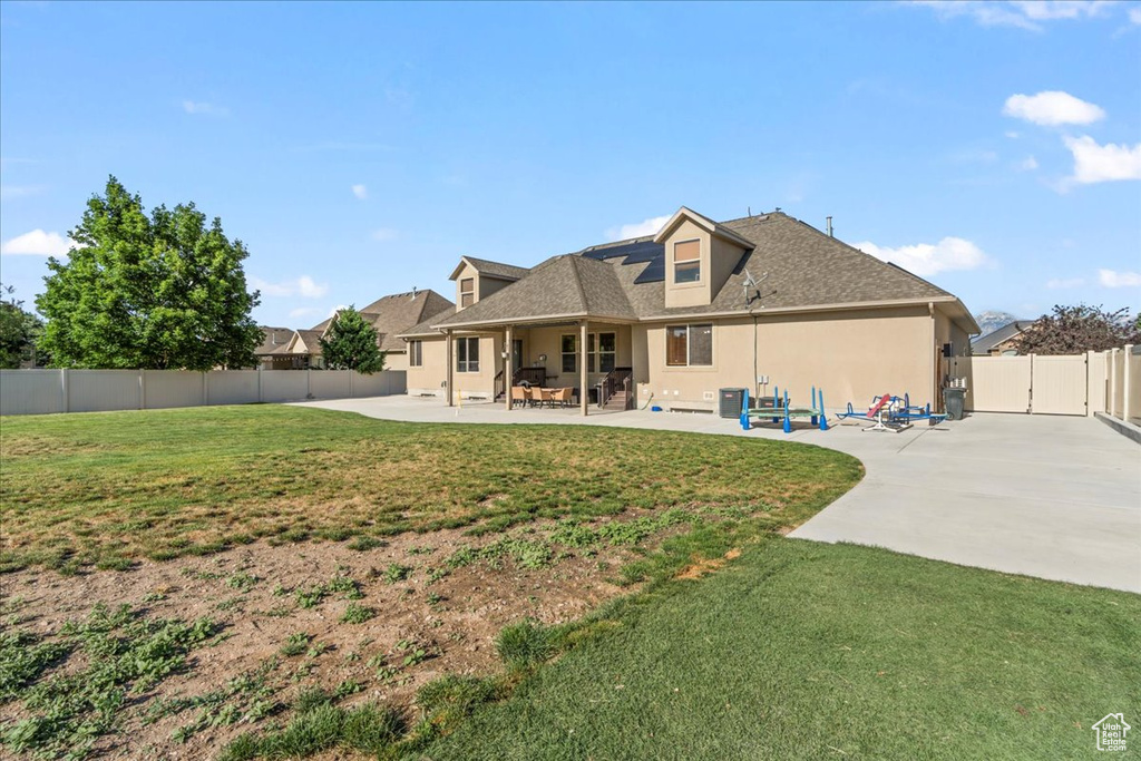 Back of house featuring a patio area, stucco siding, and a shingled roof