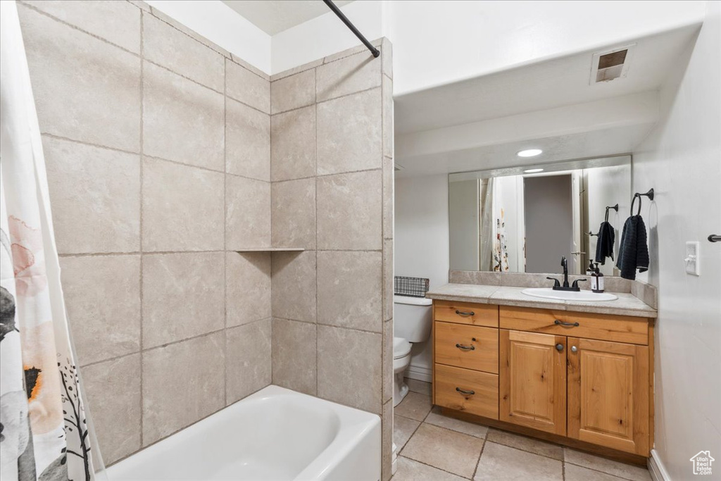 Bathroom with vanity, shower / tub combo, toilet, and tile patterned floors