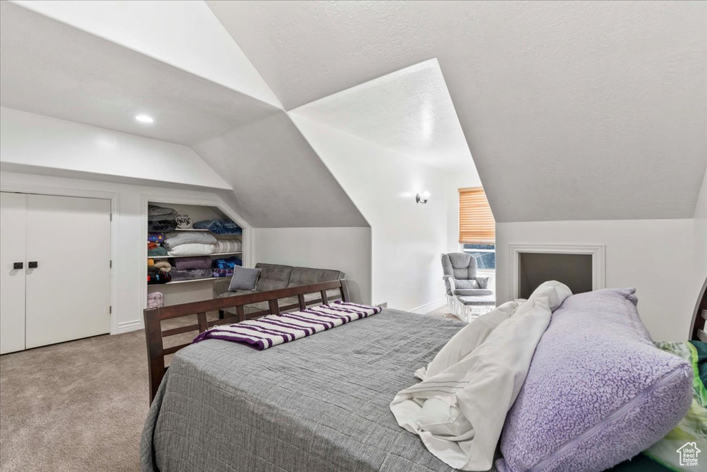 Carpeted bedroom with lofted ceiling