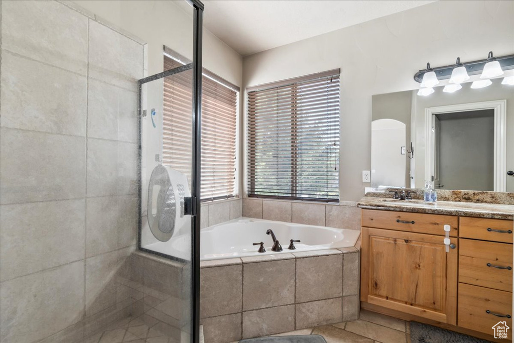 Bathroom featuring vanity, a garden tub, a stall shower, and tile patterned floors