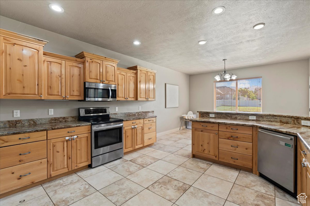 Kitchen featuring stainless steel appliances, recessed lighting, a textured ceiling, a chandelier, and light tile patterned floors