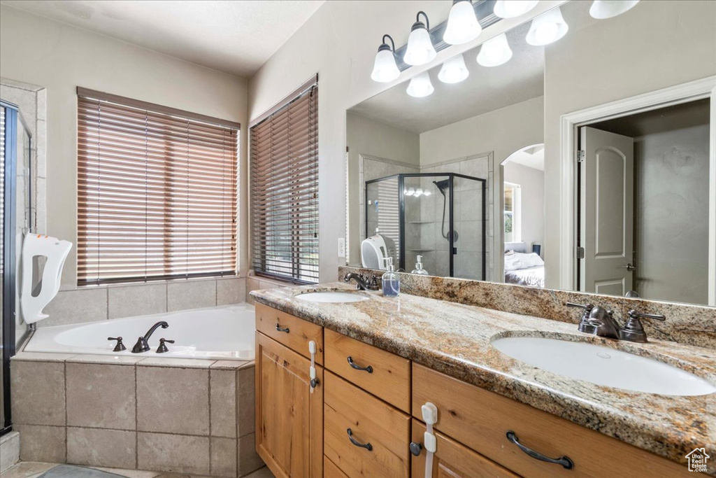 Full bath featuring a shower stall, a bath, and double vanity