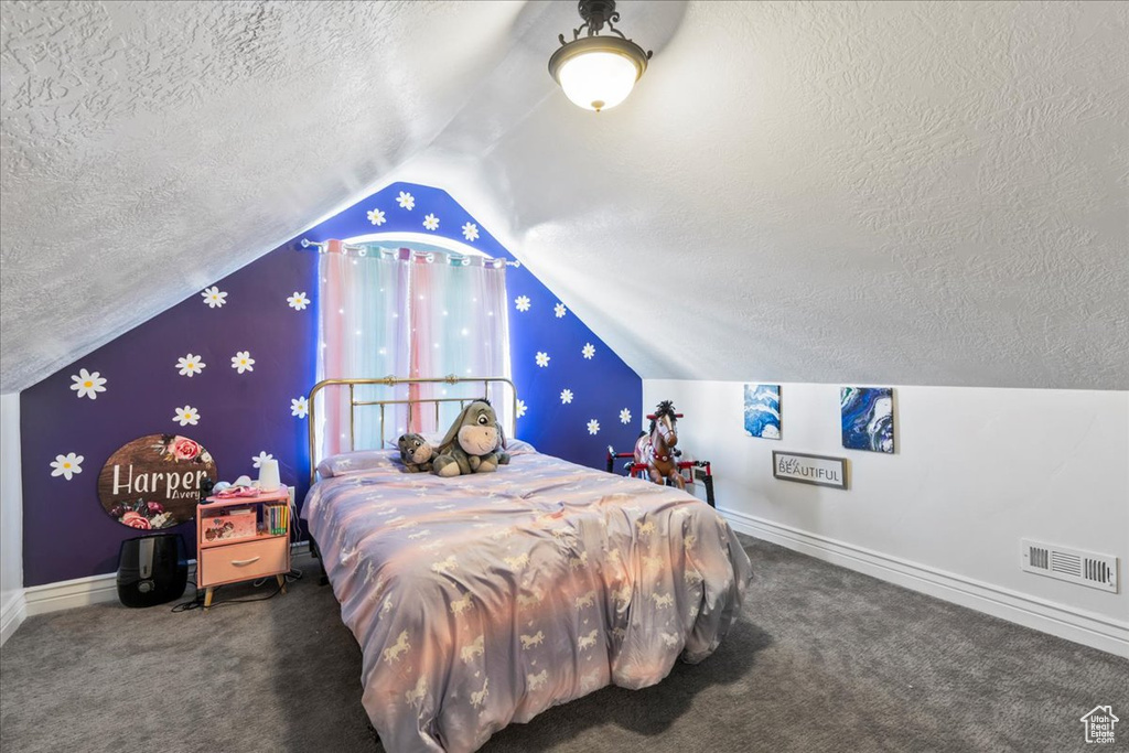Bedroom featuring a textured ceiling, vaulted ceiling, carpet floors, and baseboards