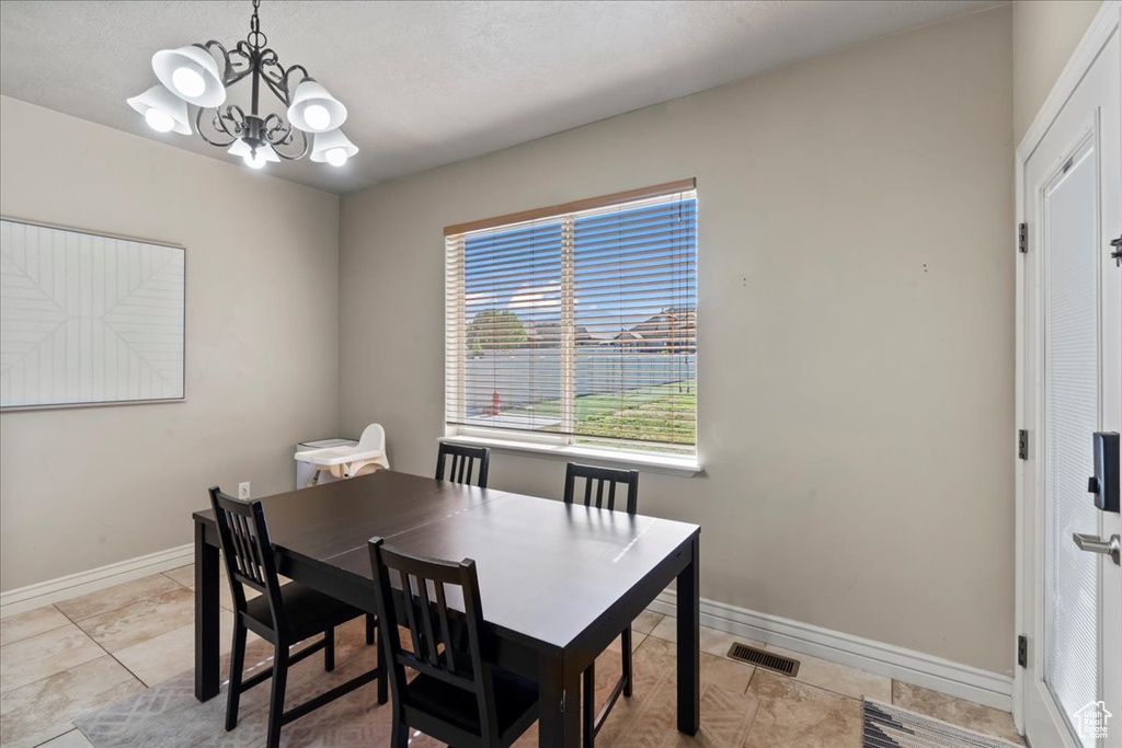 Dining room with a chandelier, baseboards, and light tile patterned floors