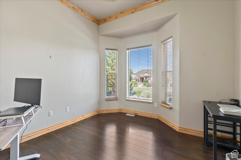 Unfurnished office featuring baseboards, wood finished floors, and ornamental molding