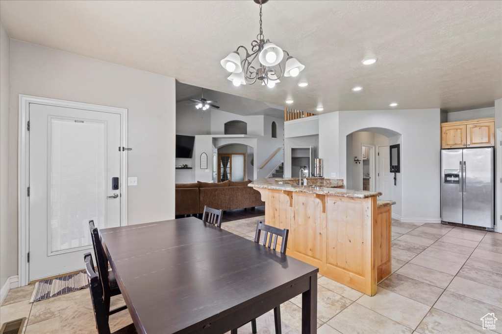 Dining room with arched walkways, baseboards, a chandelier, a ceiling fan, and recessed lighting