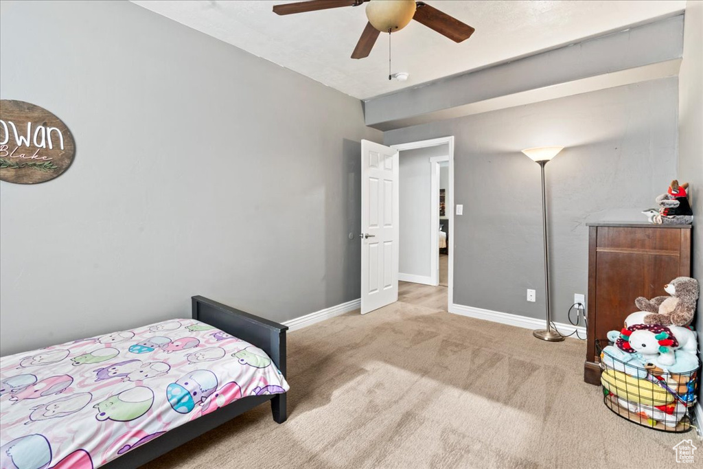 Carpeted bedroom with baseboards and a ceiling fan