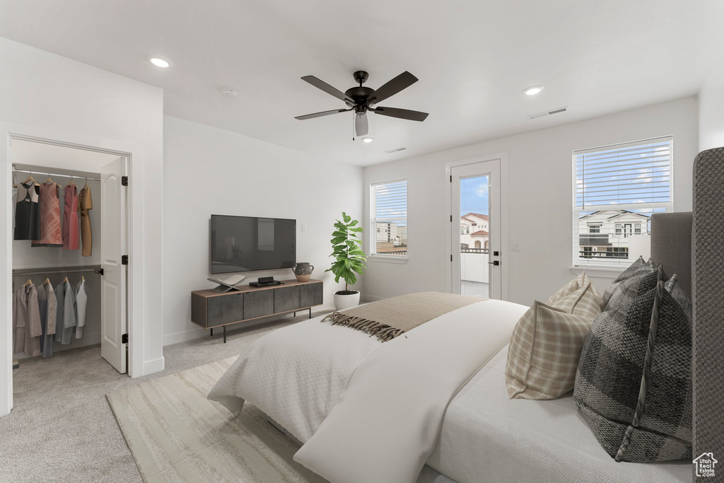 Bedroom with light colored carpet, recessed lighting, ceiling fan, a walk in closet, and baseboards
