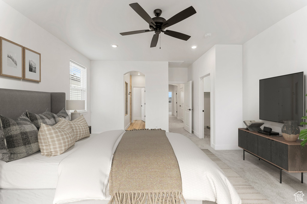 Bedroom featuring arched walkways, light carpet, recessed lighting, ceiling fan, and baseboards