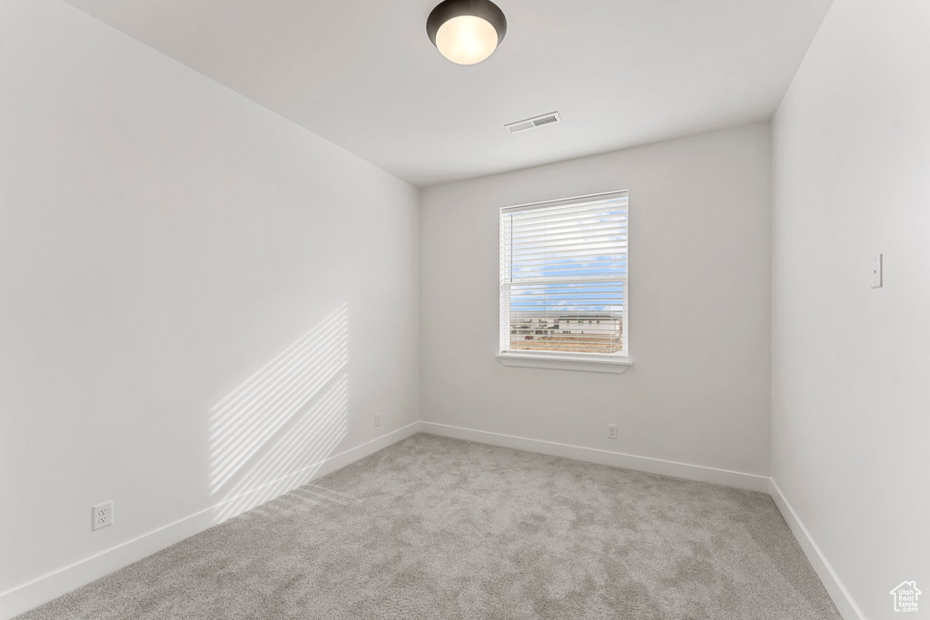 Carpeted spare room with baseboards