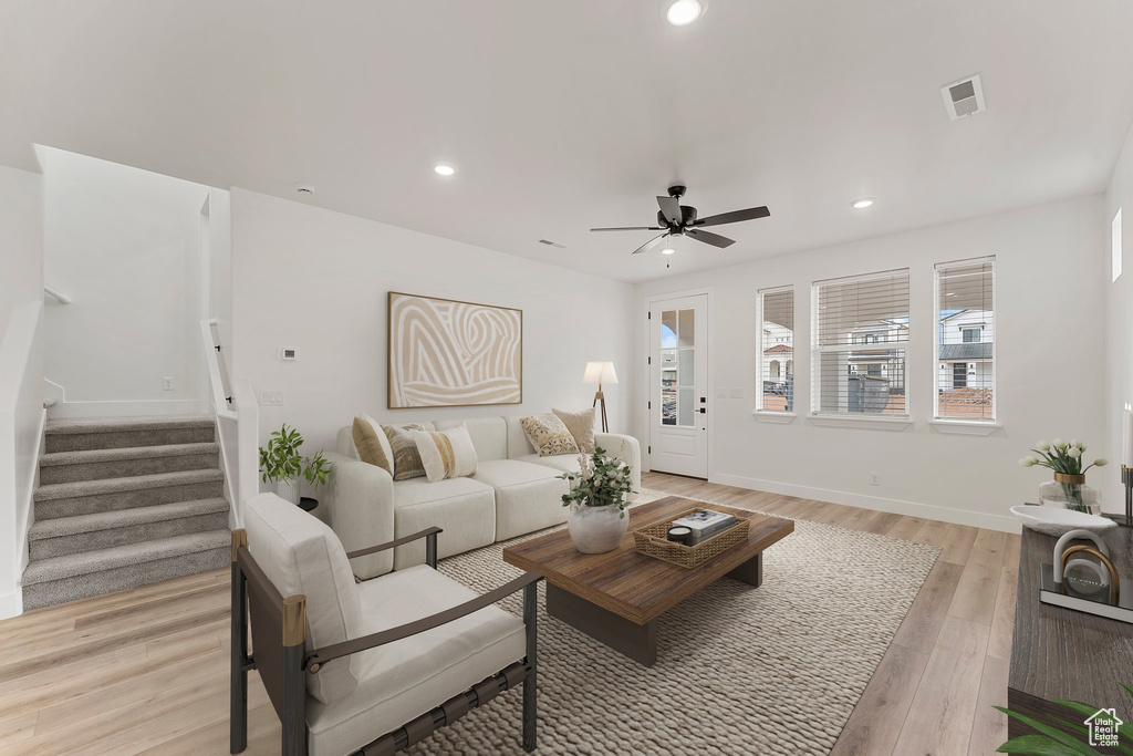 Living room featuring stairs, a ceiling fan, recessed lighting, light wood-style flooring, and baseboards