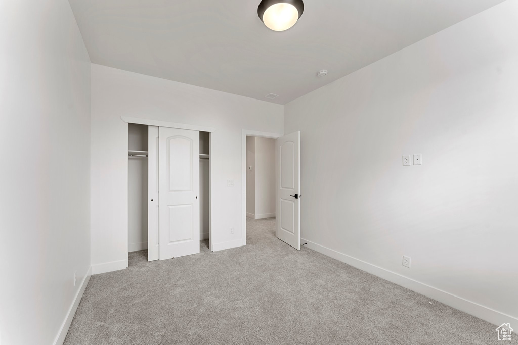 Unfurnished bedroom with carpet floors, baseboards, and a closet